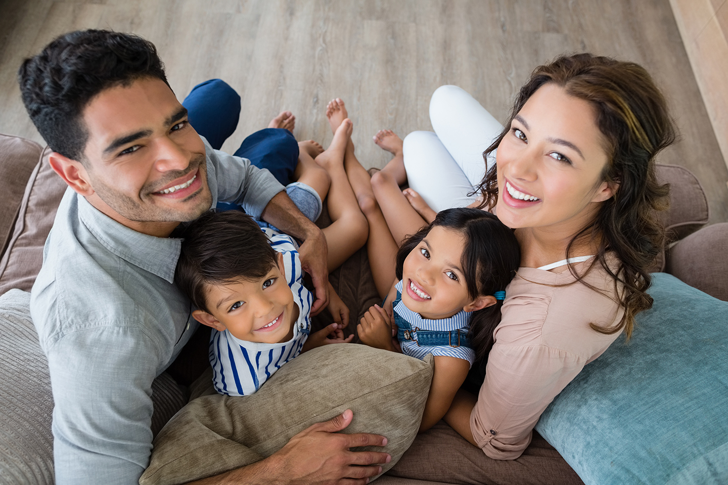 portrait-of-happy-parents-and-kids-sitting-on-sofa-2026-01-09-11-14-12-utc